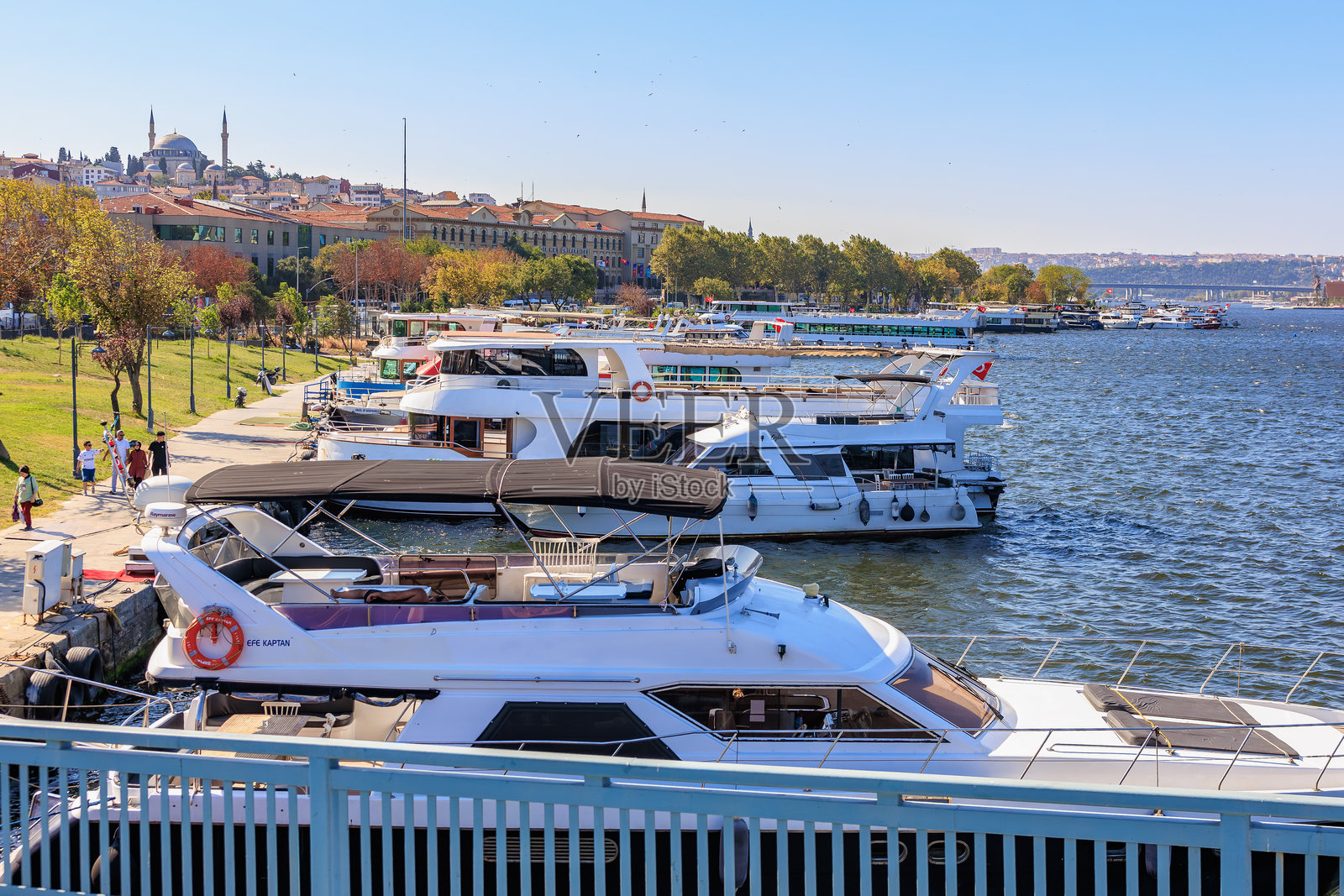 晴朗天气下的风景如画的海滨，有船只和城市景观。照片摄影图片