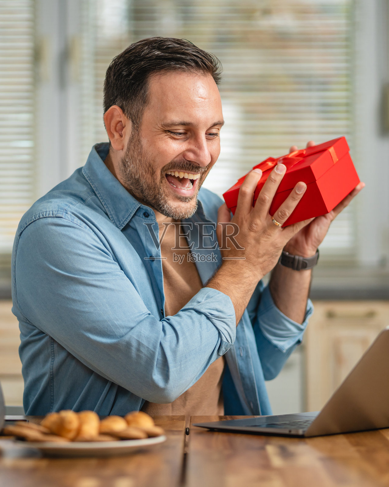 在家视频通话时收到礼物的男人照片摄影图片