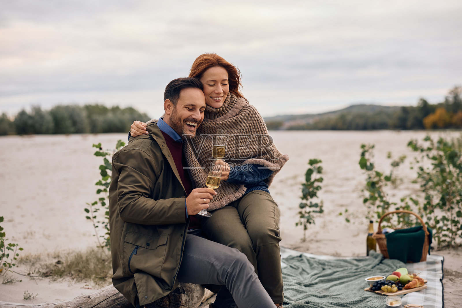 秋日野餐，一对幸福的情侣正在享用香槟。照片摄影图片