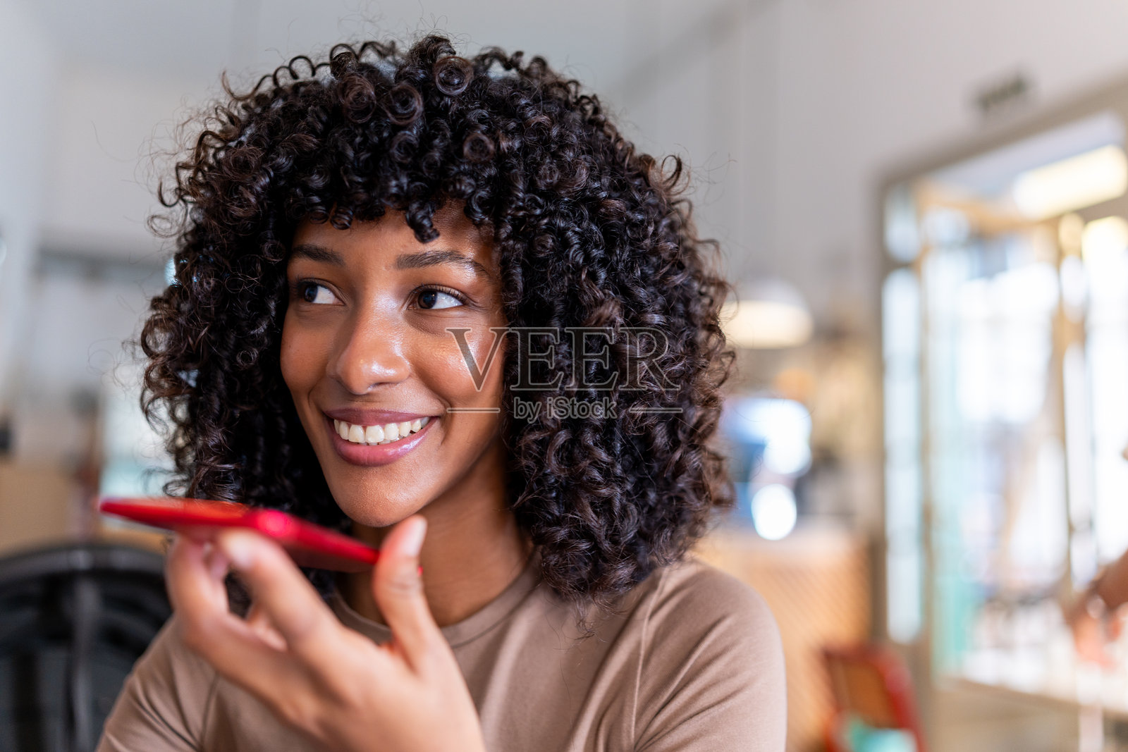 年轻女子微笑着通过手机发送语音消息照片摄影图片