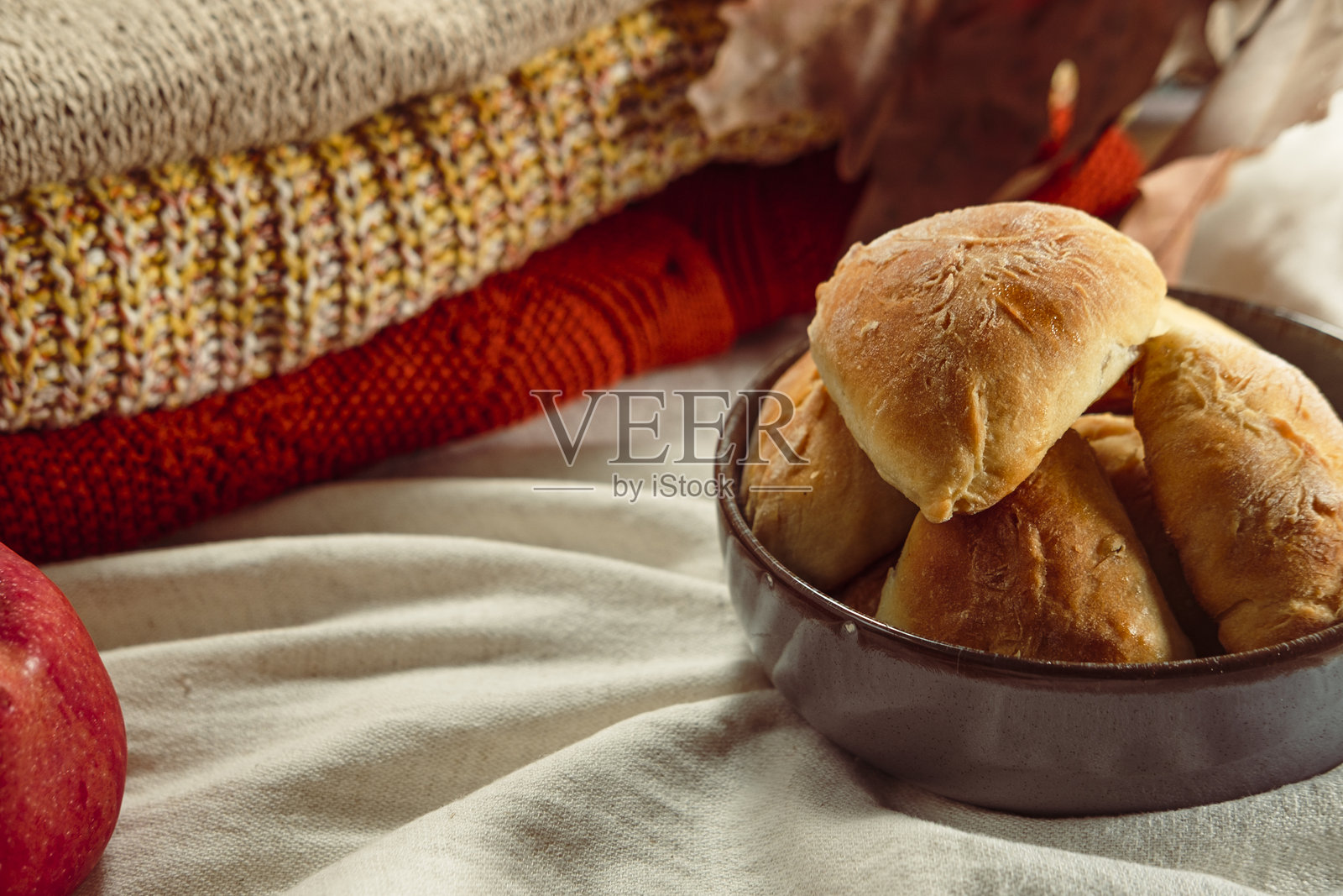 秋季烘焙，苹果派糕点，乌克兰传统面包店，舒适的氛围，配有苹果、肉桂棒、白色亚麻纺织品和暖色调针织品照片摄影图片