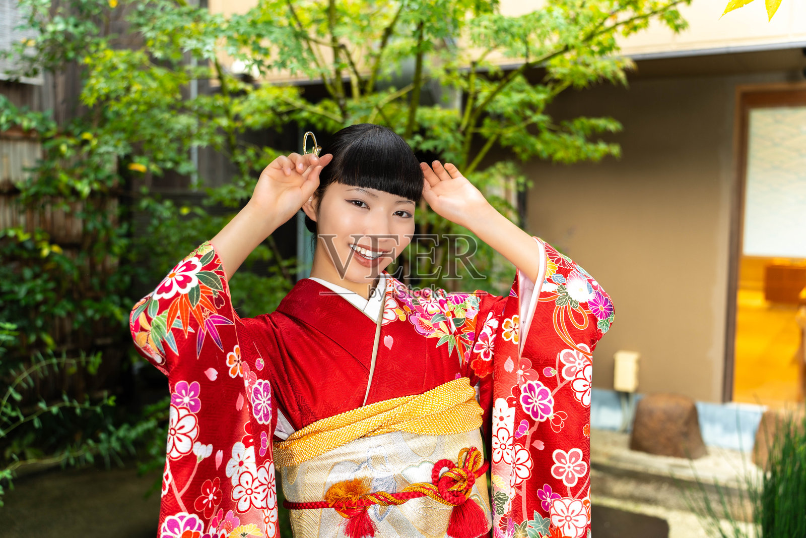 身穿振袖和服的日本女性在花园里站立照片摄影图片