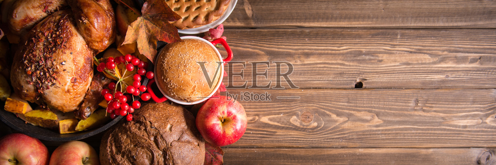 传统的感恩节静物。烤火鸡、南瓜派、蔓越莓、秋季南瓜和坚果摆放在深色木桌上。俯视视角。节日概念。照片摄影图片
