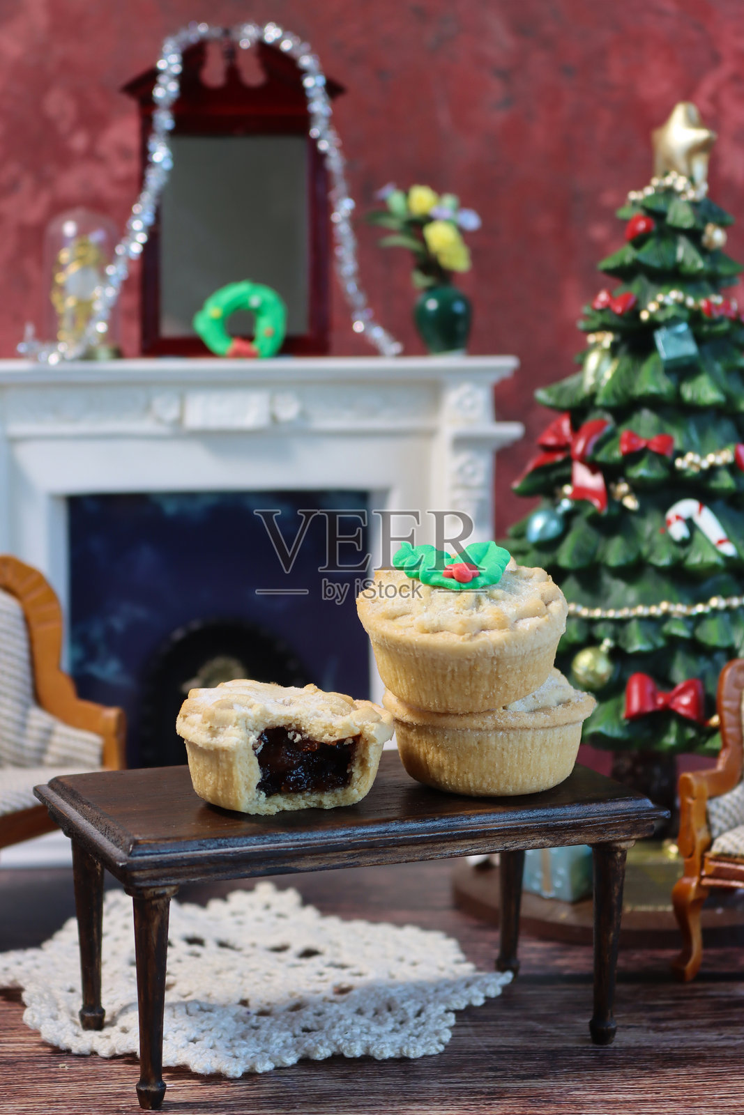 舒适的圣诞娃娃屋场景，有圣诞肉馅饼、壁炉和节日客厅的圣诞树装饰照片摄影图片