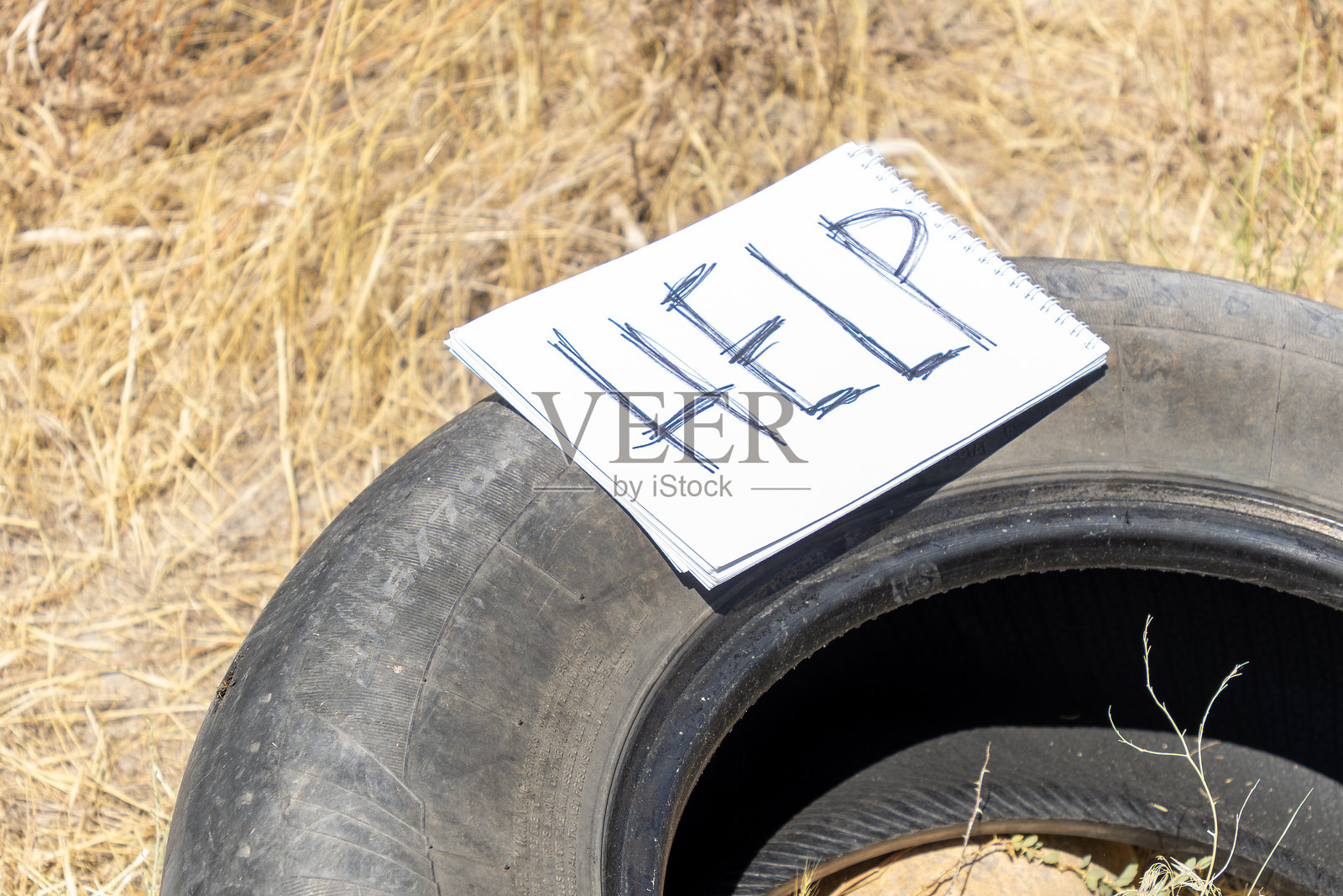 一个写着“救命”的轮胎孤零零地躺在地上照片摄影图片