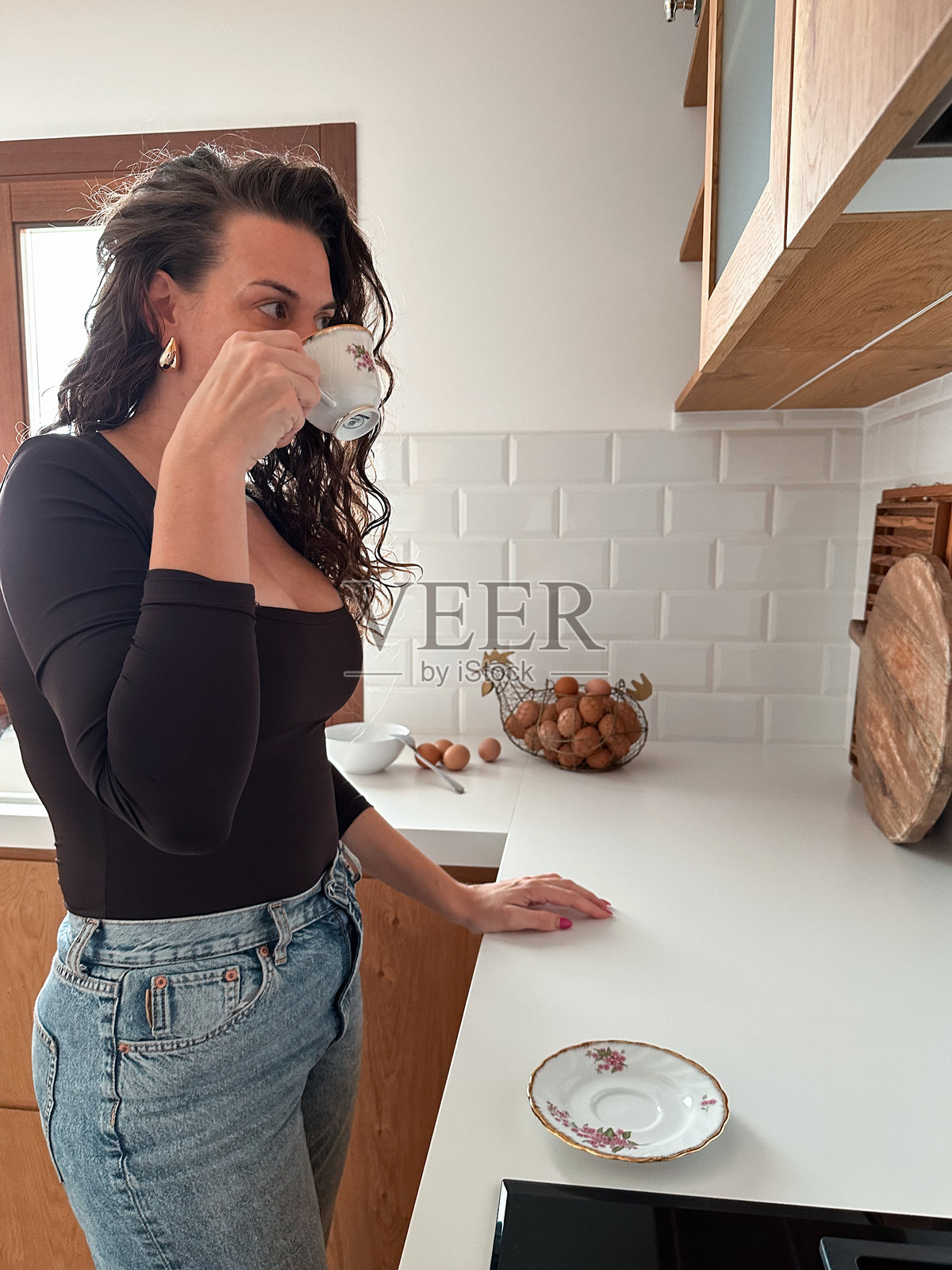 女人在家厨房里站着喝咖啡照片摄影图片