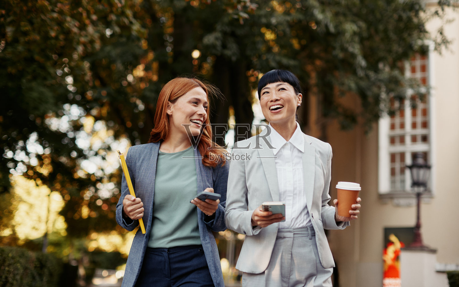 两位女同事专业地边走边谈照片摄影图片