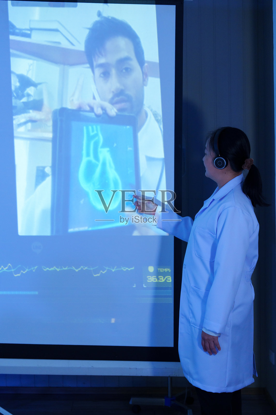 医生和护士在会议室通过视频会议讨论和分析患者的心脏病。照片摄影图片