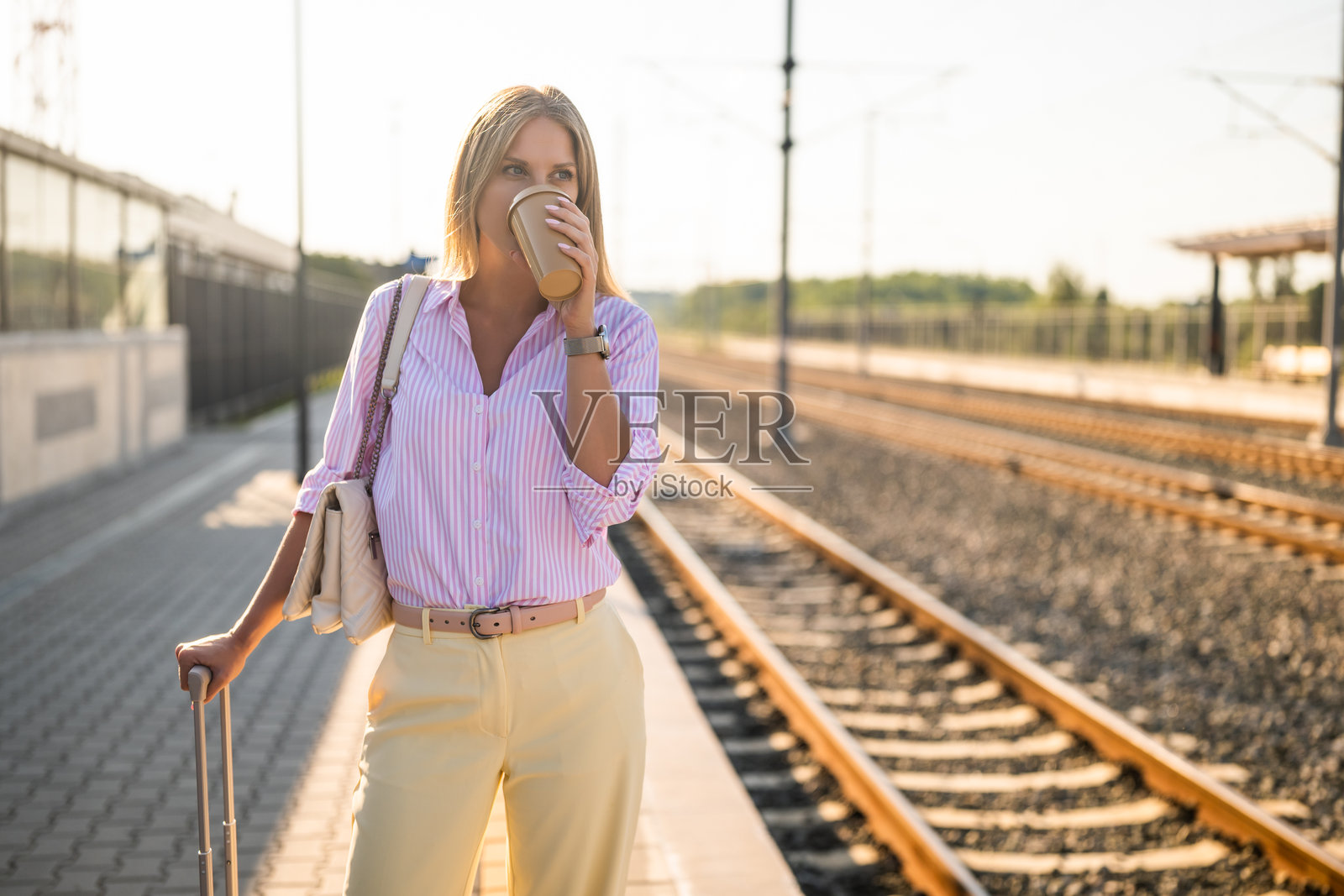 时尚女商人站在火车站喝咖啡照片摄影图片