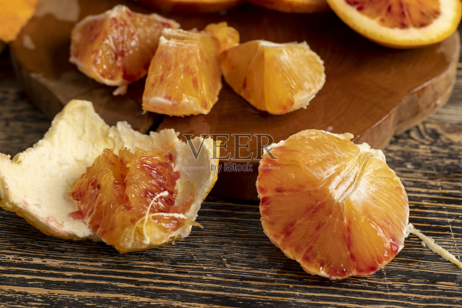 桌上切好的成熟多汁的橙子，带有红色和橙色的果肉，新鲜多汁的橙子切成块，富含健康维生素照片摄影图片