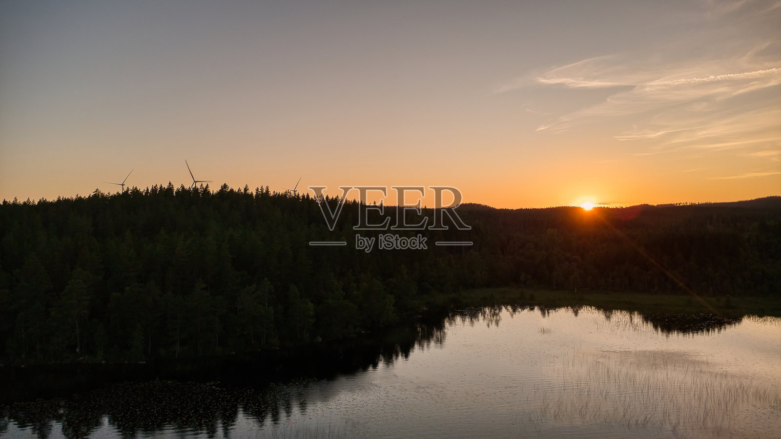 夕阳下的湖泊，有倒影和森林，宁静的夜晚氛围照片摄影图片