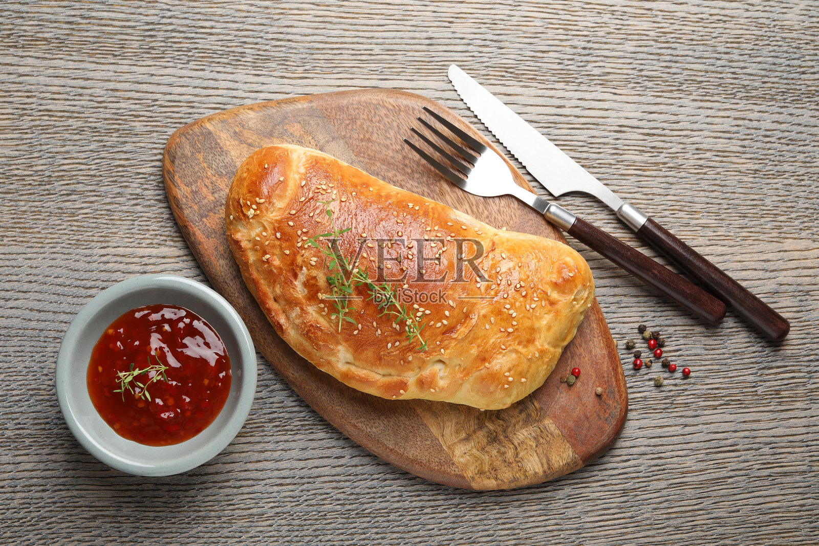 美味新鲜的卡尔佐内披萨放在木桌上，俯视角度照片摄影图片