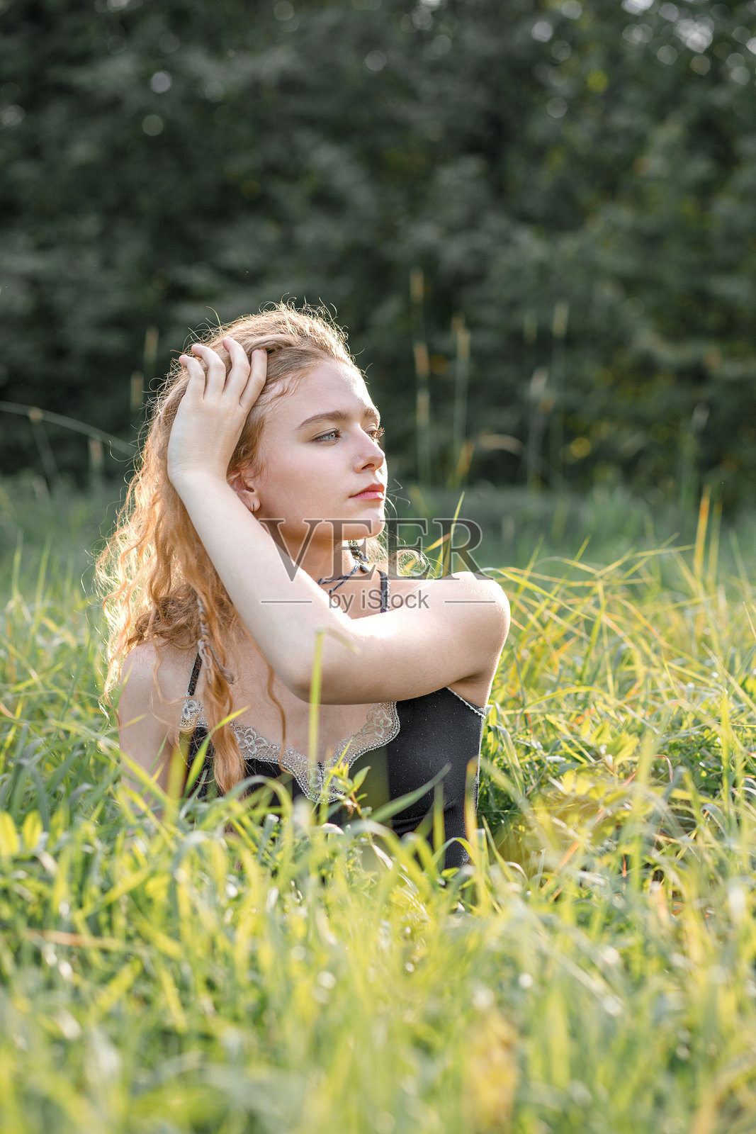 日落时分，年轻的嬉皮士女子在自然背景前摆拍的时尚肖像照片摄影图片