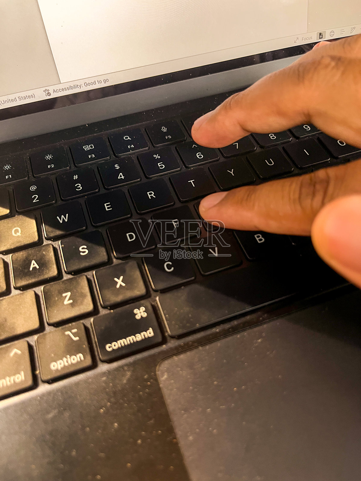 在现代工作空间中，在笔记本电脑键盘上打字的手照片摄影图片