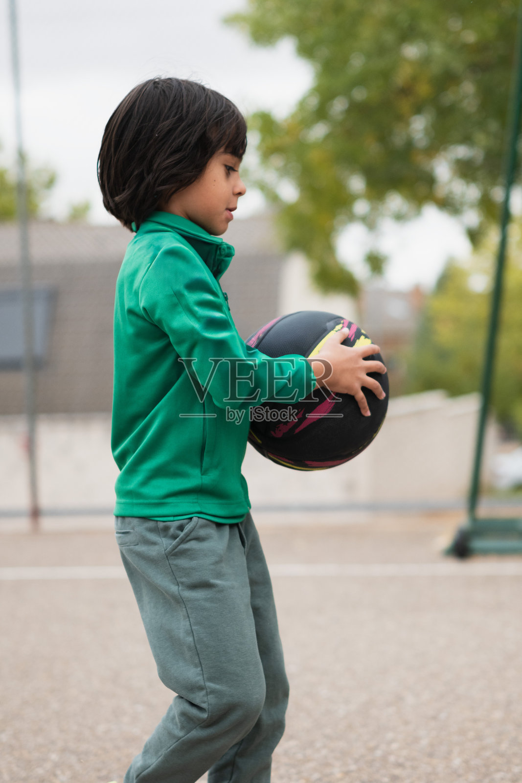 孩子在户外打篮球，象征着活力与童年照片摄影图片