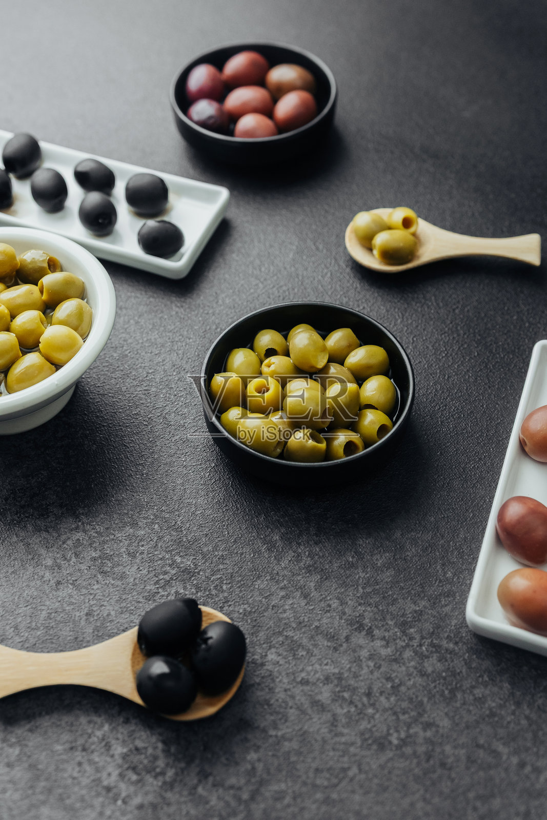 深色背景下各种橄榄的特写，包括绿橄榄、黑橄榄和卡拉马塔橄榄照片摄影图片