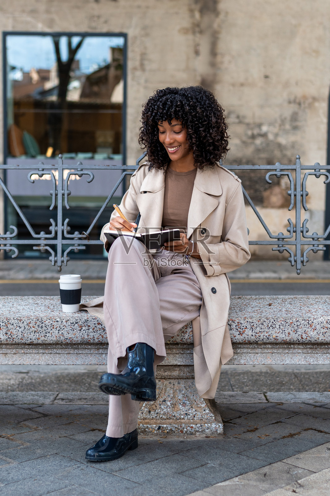 年轻女子在笔记本上写作，享受城市生活照片摄影图片