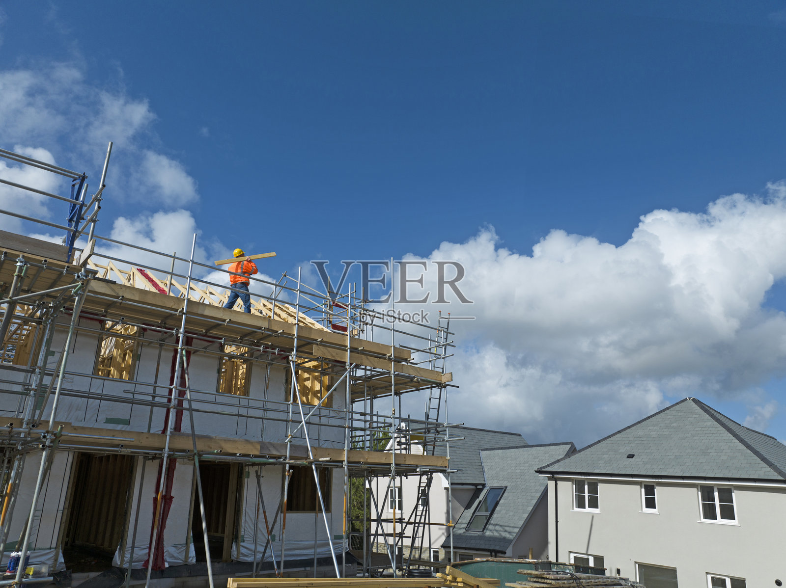 高处俯瞰，建筑工人在屋顶桁架上作业照片摄影图片