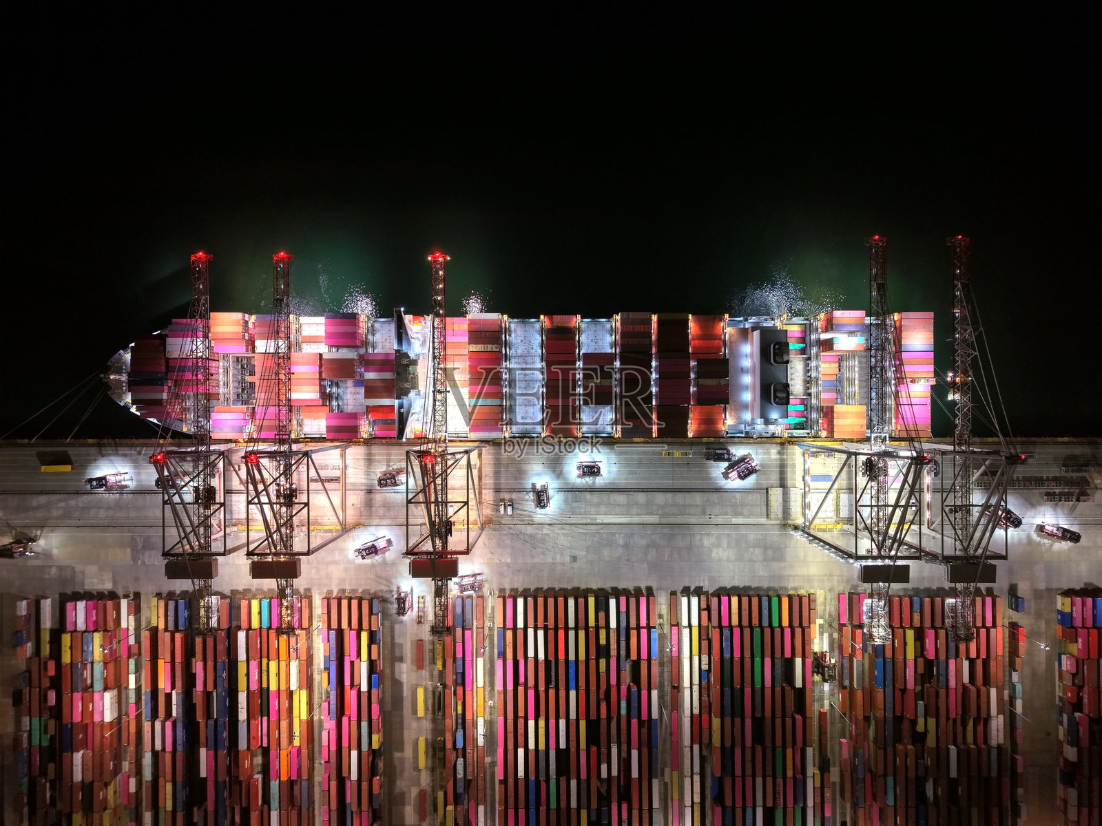 工业 shipping 港口鸟瞰图。无人机视角。集装箱装船，起重机装载集装箱。夜间拍摄。照片摄影图片