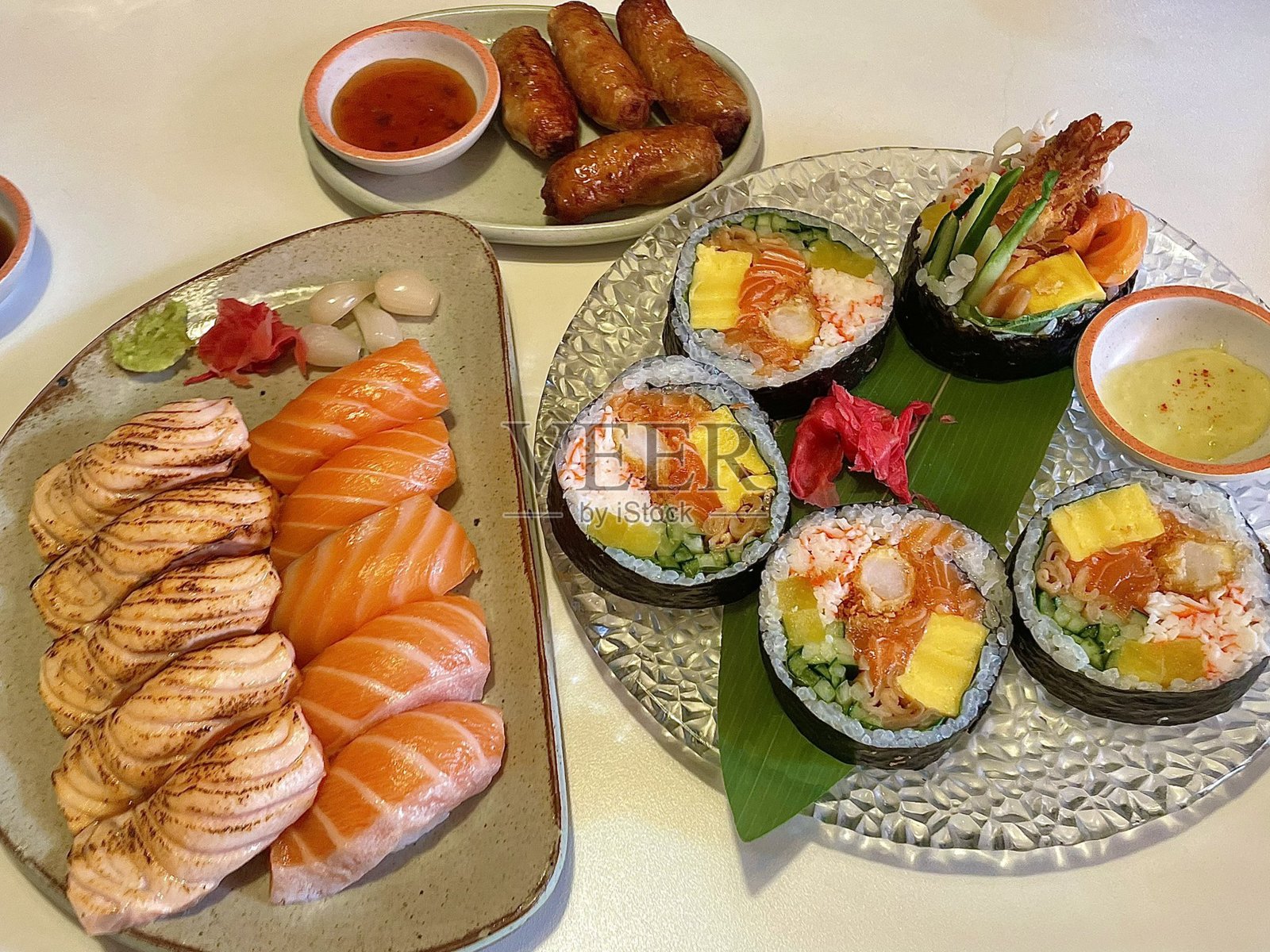 各种新鲜寿司，摆盘精美，搭配多样配料，色彩鲜艳。这道传统的日本料理将醋饭、海鲜和蔬菜融合在一起，带来美妙的味觉体验。照片摄影图片