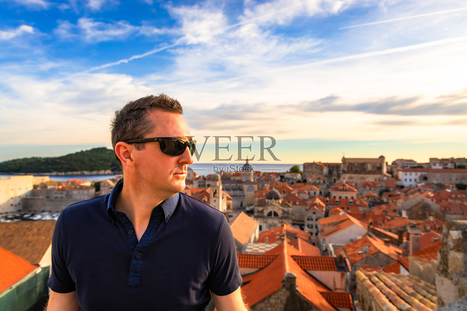 中年男性游客在克罗地亚杜布罗夫尼克老城欣赏日落照片摄影图片