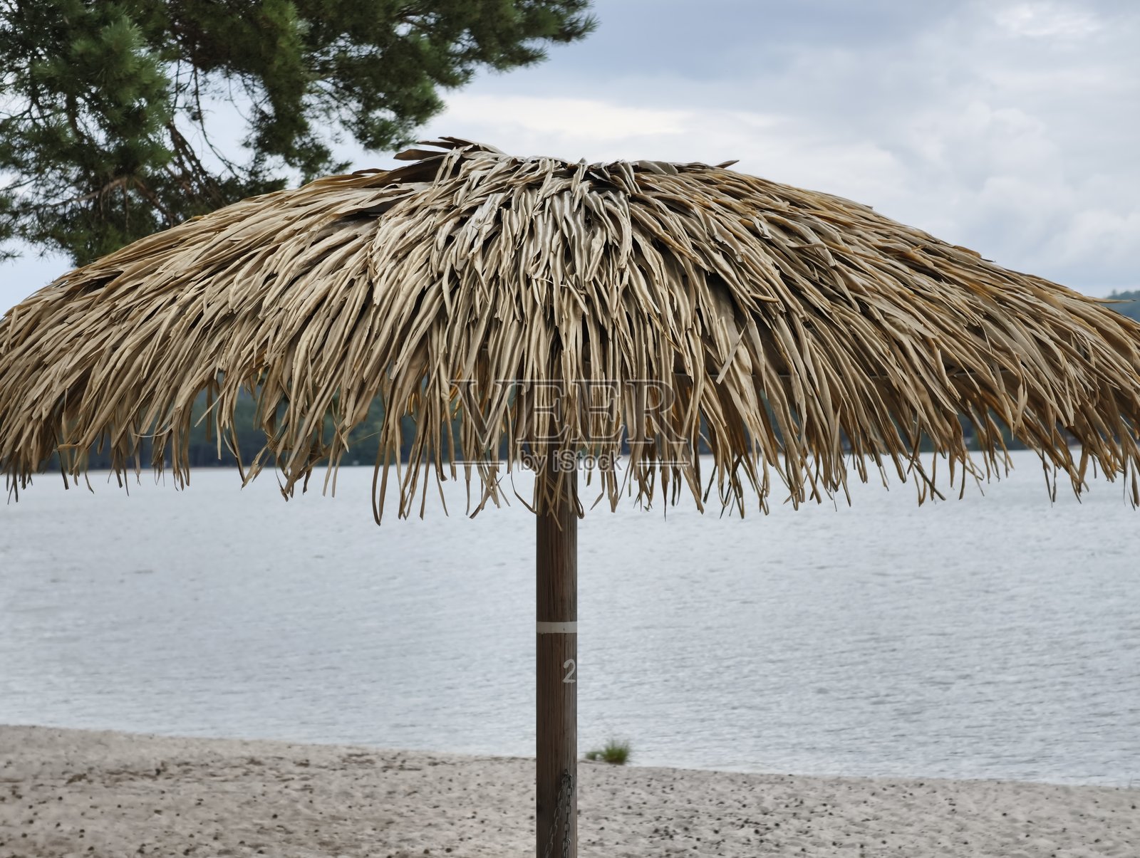 宁静湖畔一座美丽的茅草伞，是放松和享受的理想之所照片摄影图片
