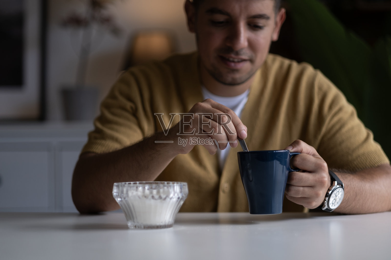 人类在咖啡或茶杯中加糖。照片摄影图片