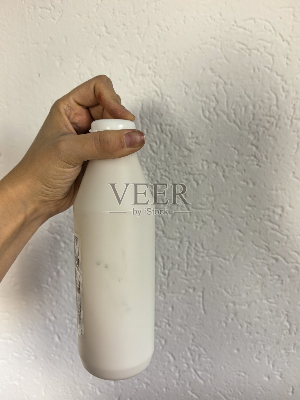 一只手拿着罐子，一只手拿着白色颜料，一罐颜料，白色颜料，手掌中的瓶子，用手拿着，女孩的手在白色背景上，艺术家，绘画照片摄影图片