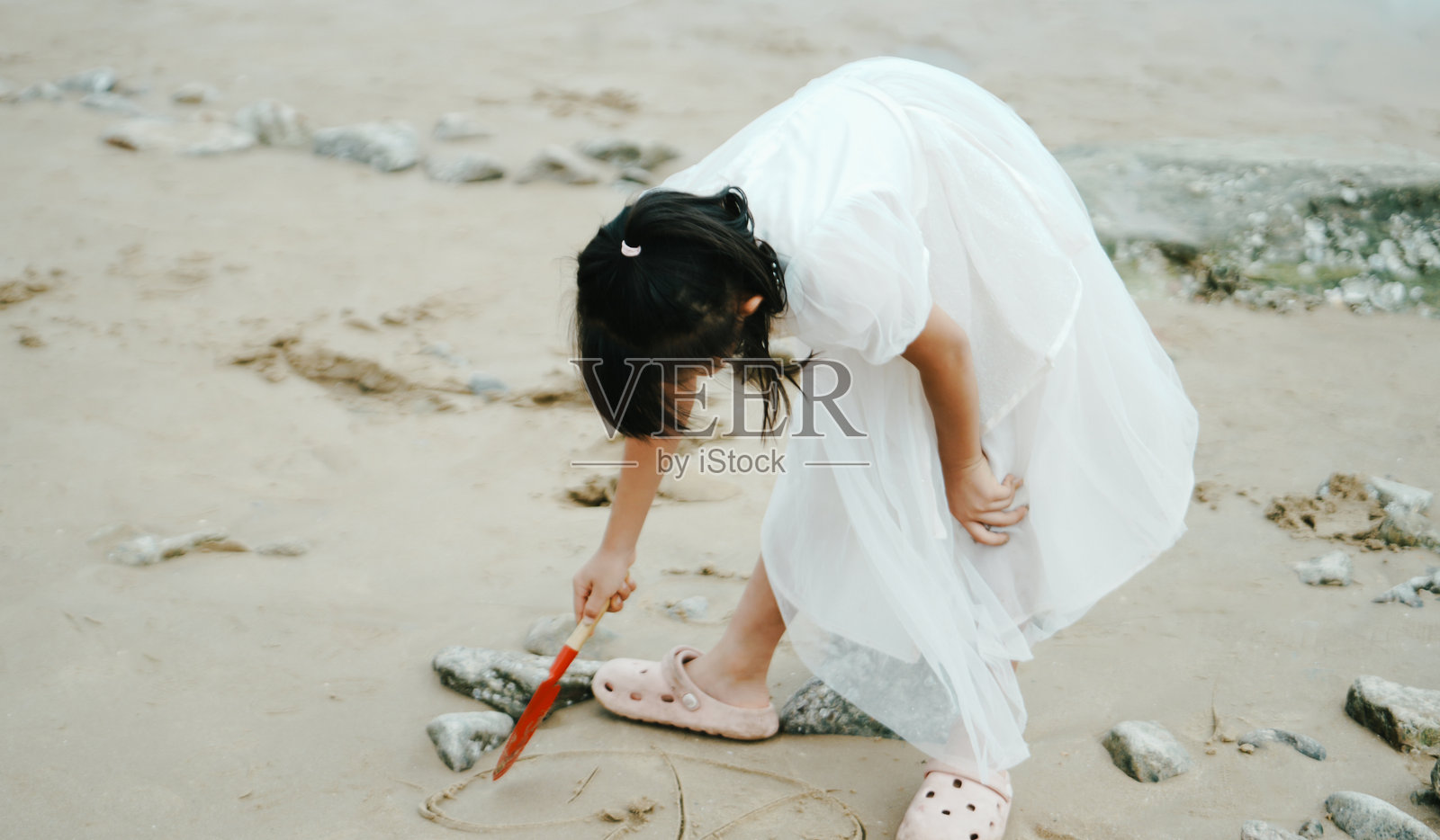 亚洲小女孩在海滩上玩耍照片摄影图片