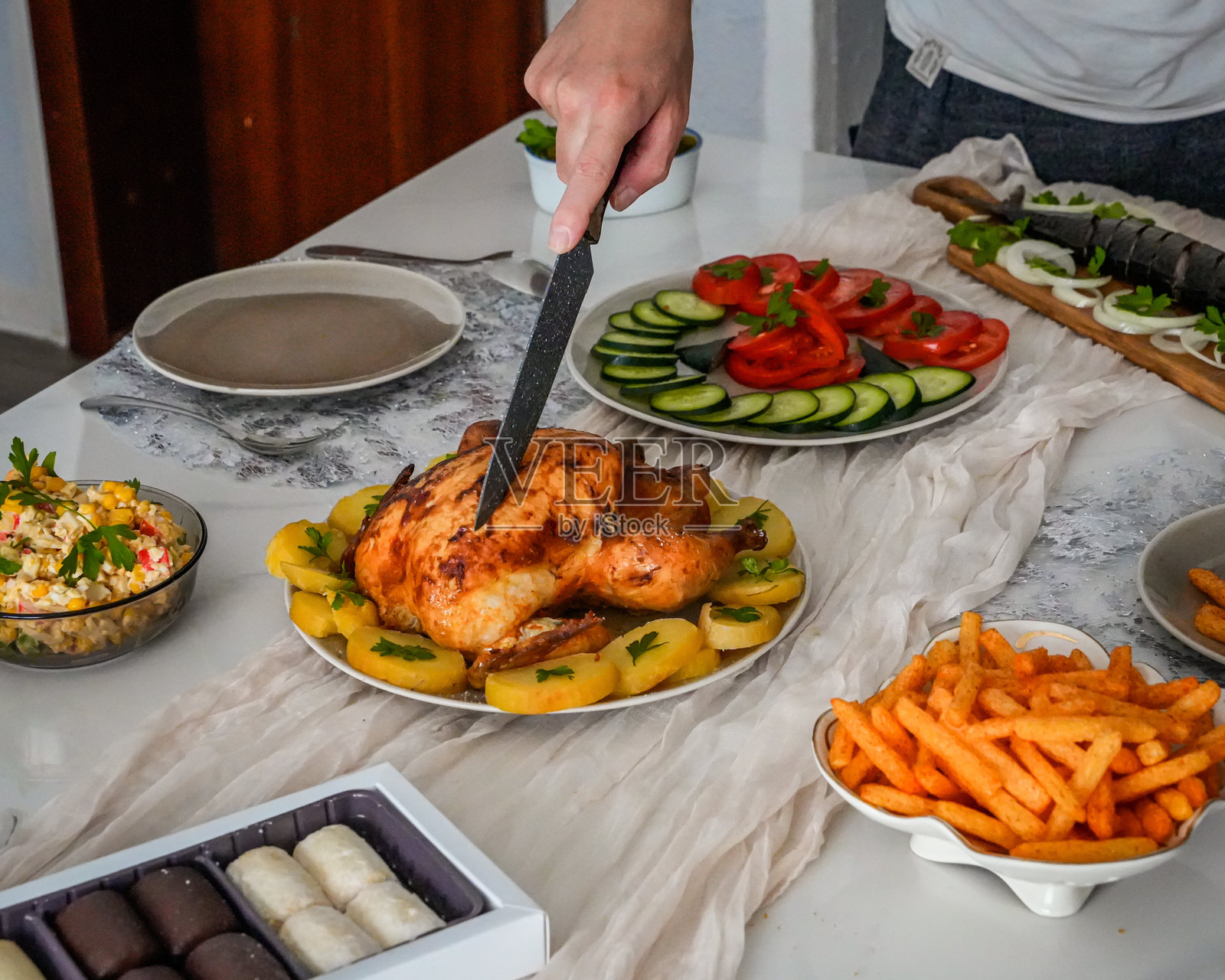 在节日餐桌上用手雕刻烤鸡照片摄影图片