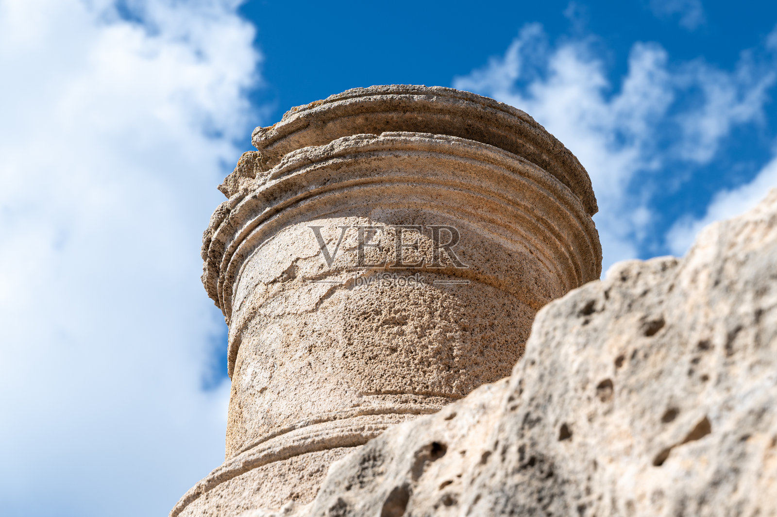 古老的石柱柱头，蓝天背景，展现建筑细节和风化纹理照片摄影图片