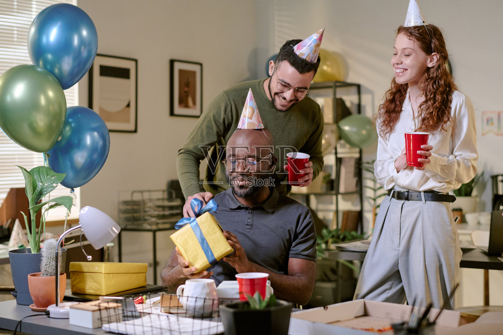 年轻多民族的同事们在办公室庆祝生日并赠送礼物照片摄影图片