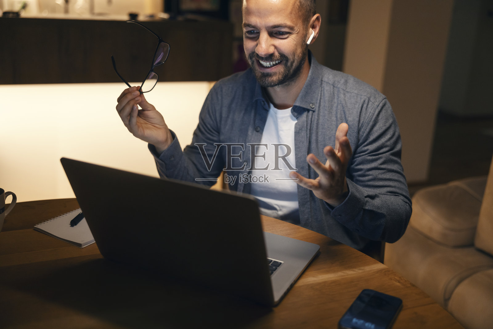 男子在夜间家中的办公室进行视频会议照片摄影图片