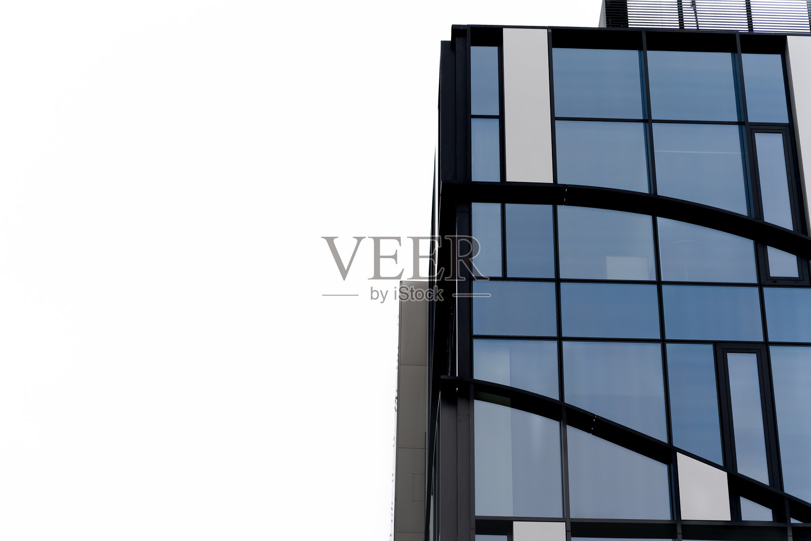 现代玻璃办公楼，背景为白色天空照片摄影图片