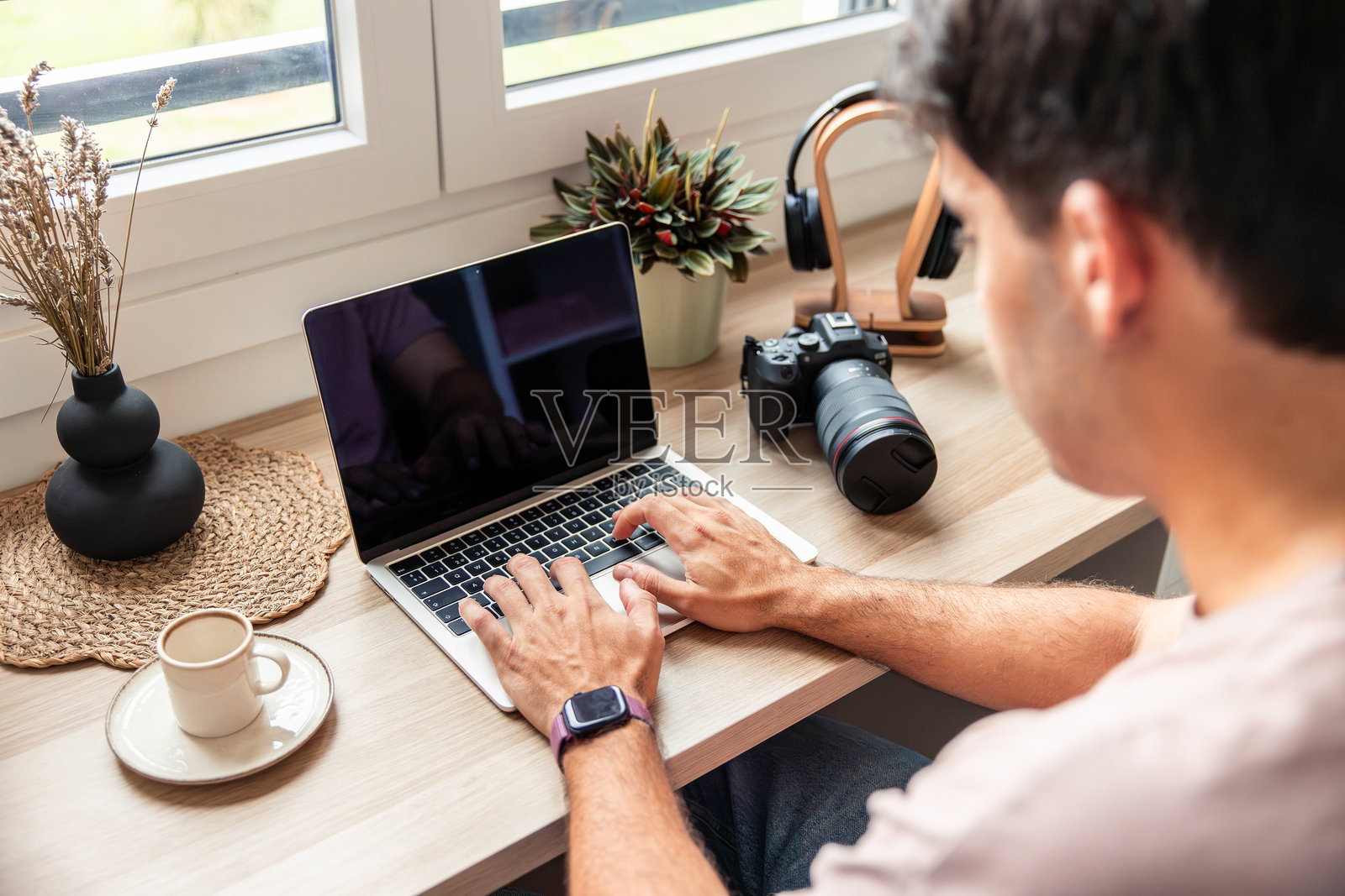 年轻的西班牙裔男性在家使用笔记本电脑远程办公照片摄影图片
