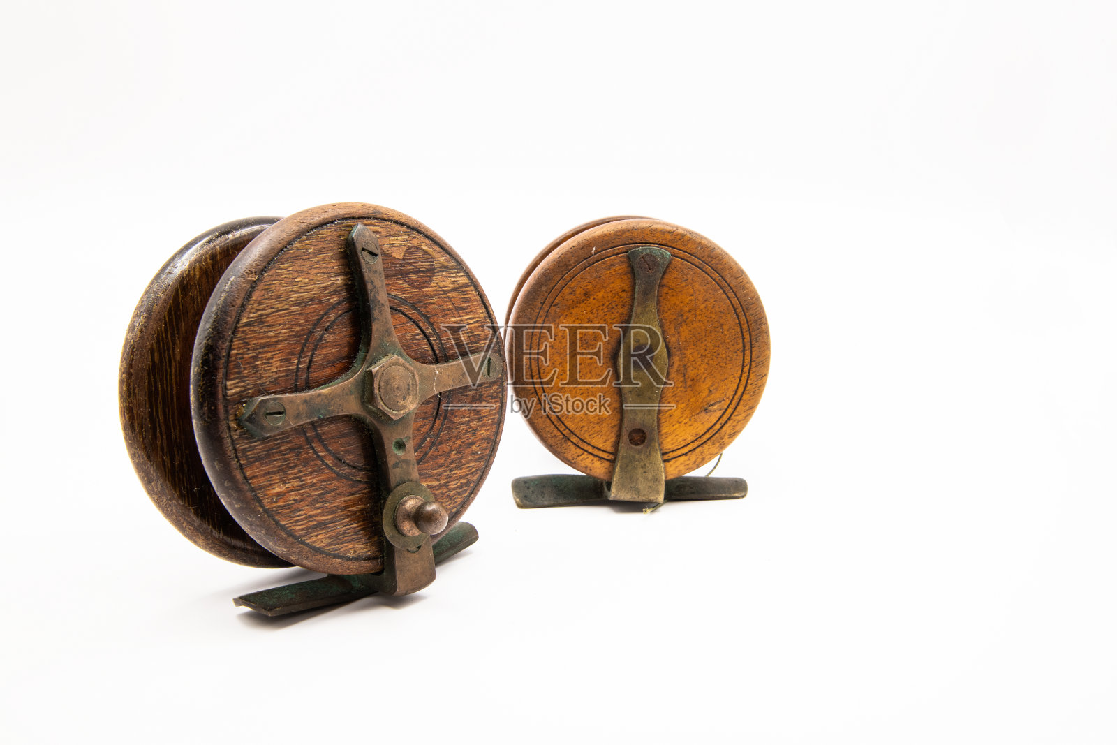 白色背景上两个木制老式中心销钓鱼轮照片摄影图片