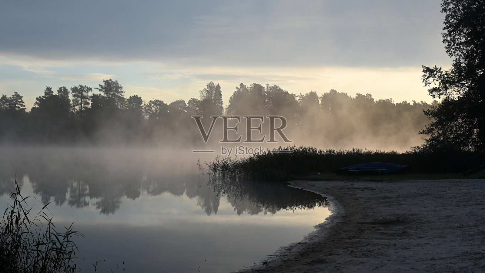 湖边初秋的早晨，薄雾遮掩了树木和灌木的轮廓，背景模糊照片摄影图片