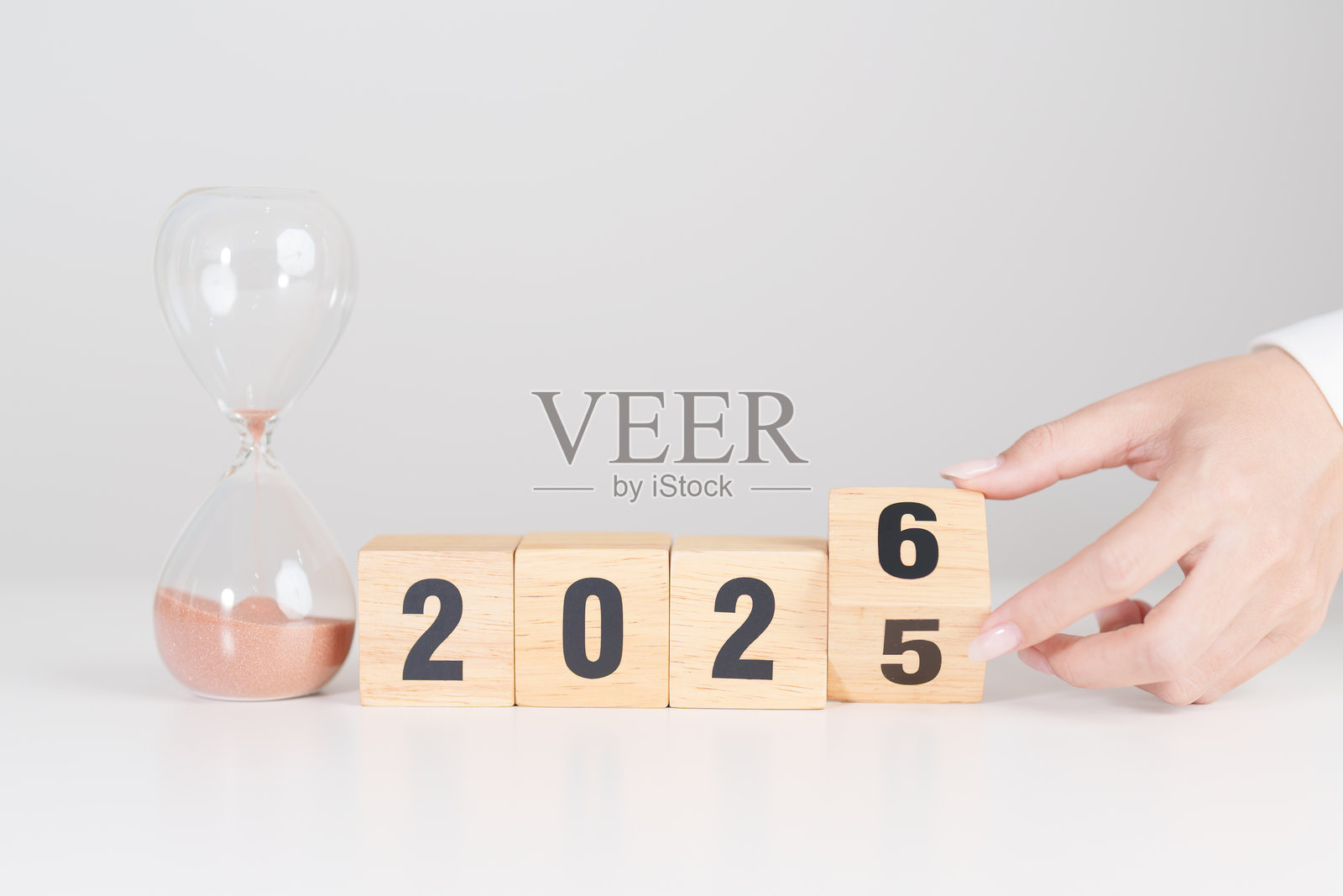 2025年末至2026年新年快乐，桌上放着一个沙漏。分辨率、时间、计划、目标、动力、重启、倒计时和新年假期概念照片摄影图片