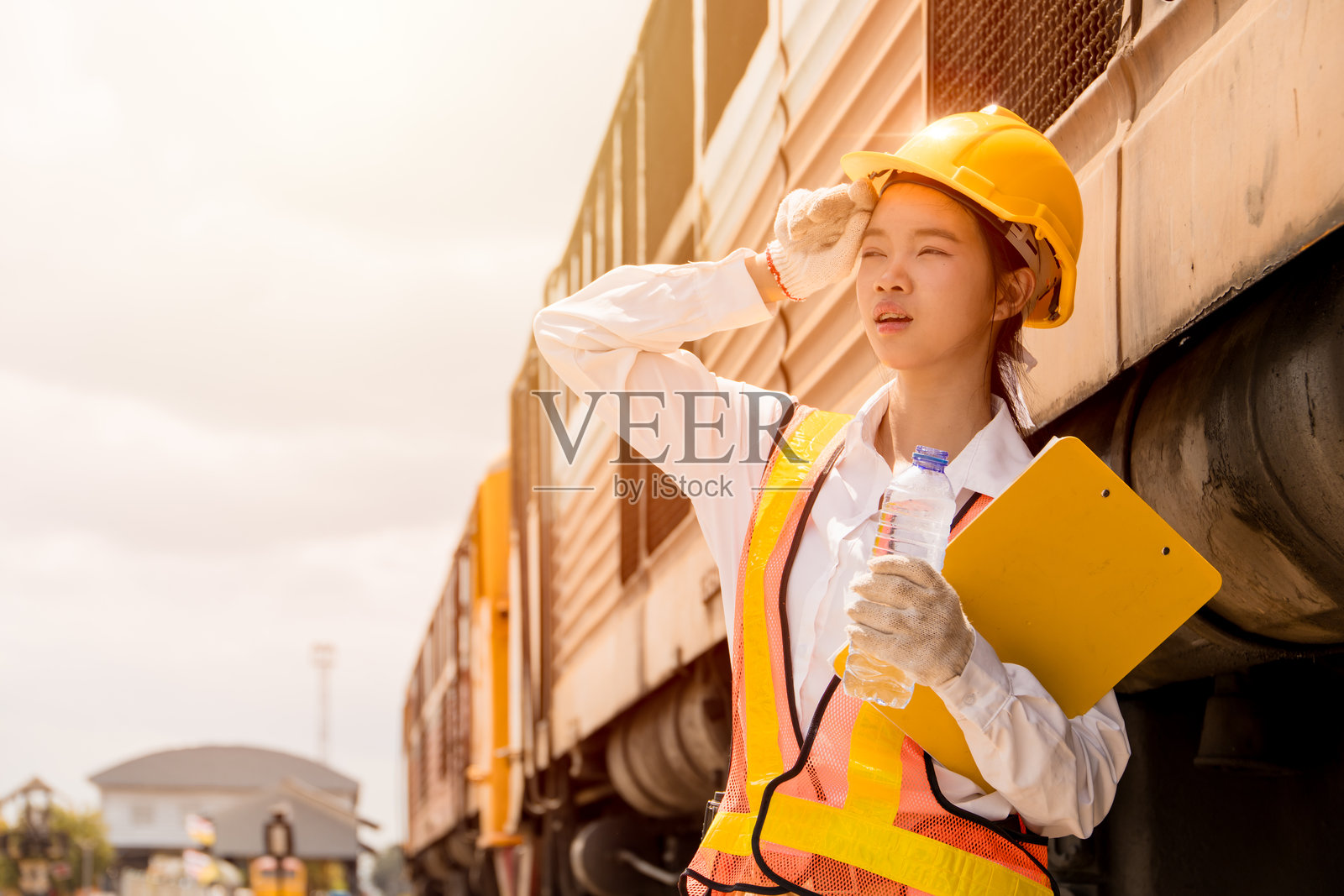 年轻的女工程师在炎热夏日户外辛勤工作后感到疲惫不堪，顶着紫外线。照片摄影图片