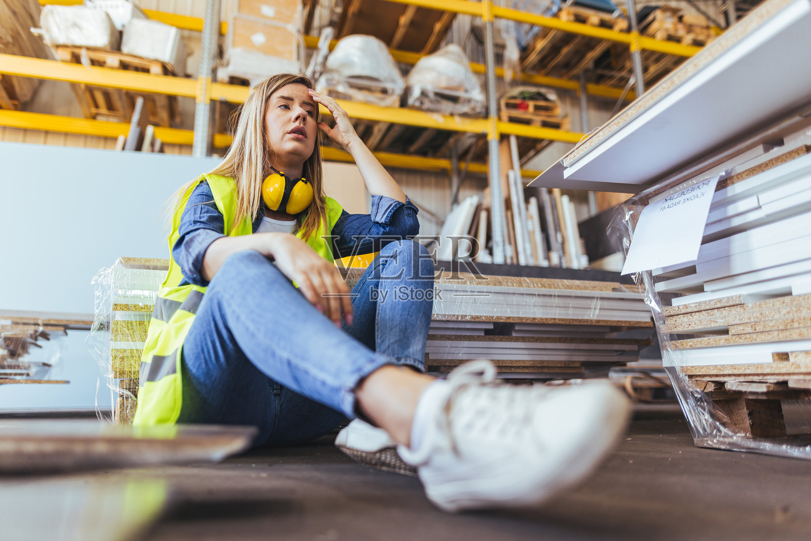 年轻工人在仓库环境中坐着沉思照片摄影图片