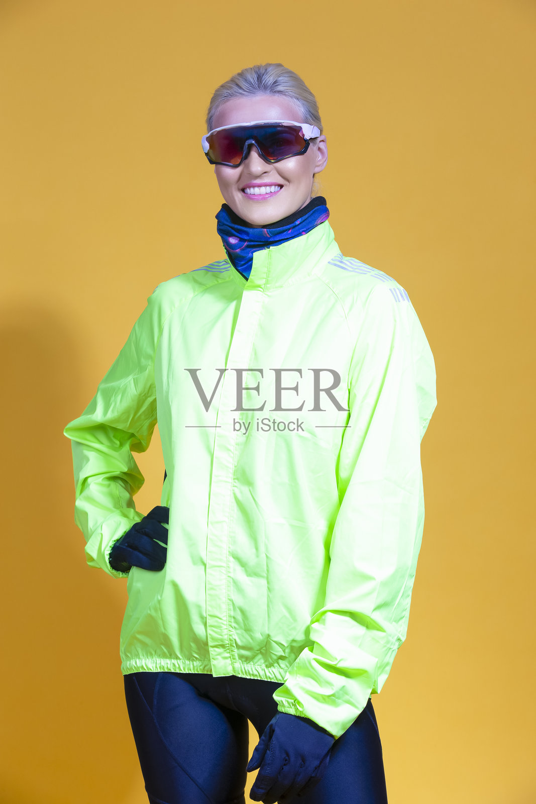 身穿鲜艳氨基黄骑行服的运动型、迷人、积极的女性骑行者，背景为黄色，自然风格肖像。照片摄影图片