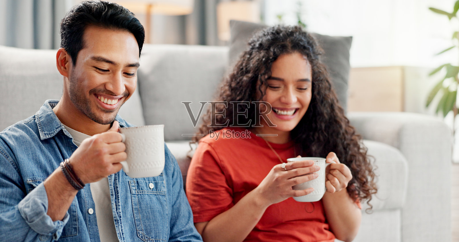 周末，一对情侣在家中放松，坐在沙发上，手捧咖啡，享受着二人世界，享受亲密、连接和浪漫的时光。他们在公寓里约会，享受饮品，畅谈，感受爱意与浪漫。照片摄影图片