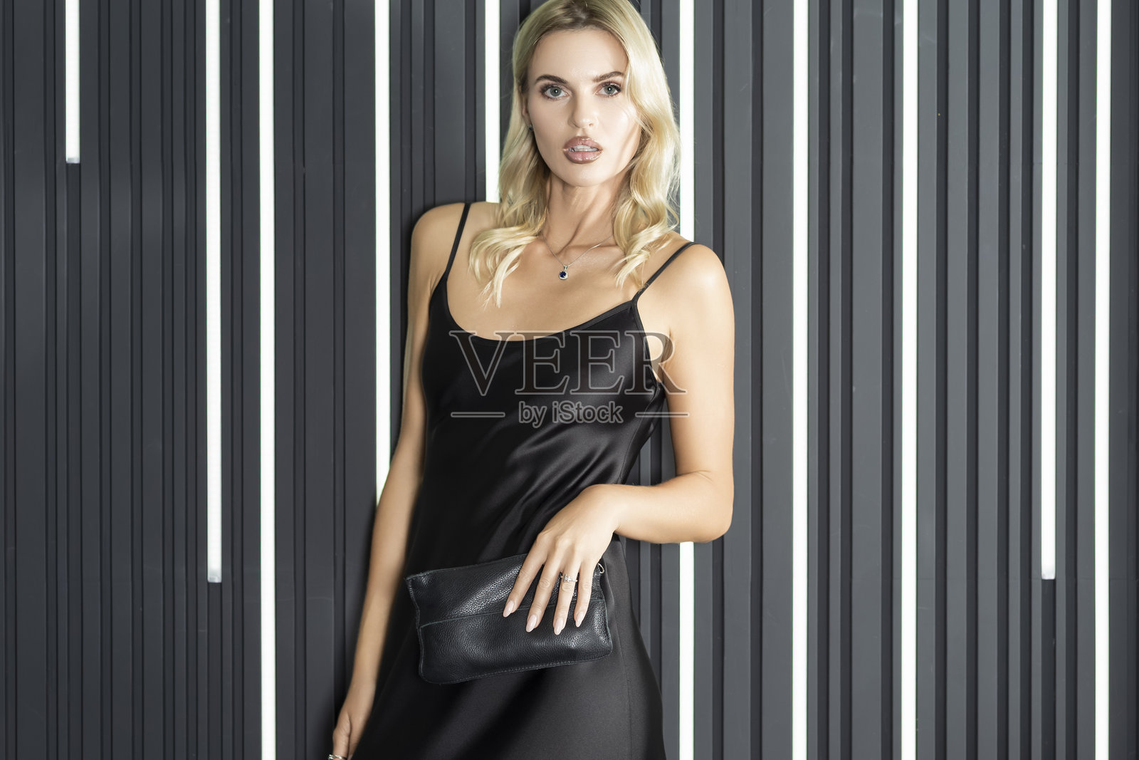 美妆与时尚概念。室内，身穿浅黑色连衣裙的迷人性感美女时尚金发模特女孩肖像照片摄影图片