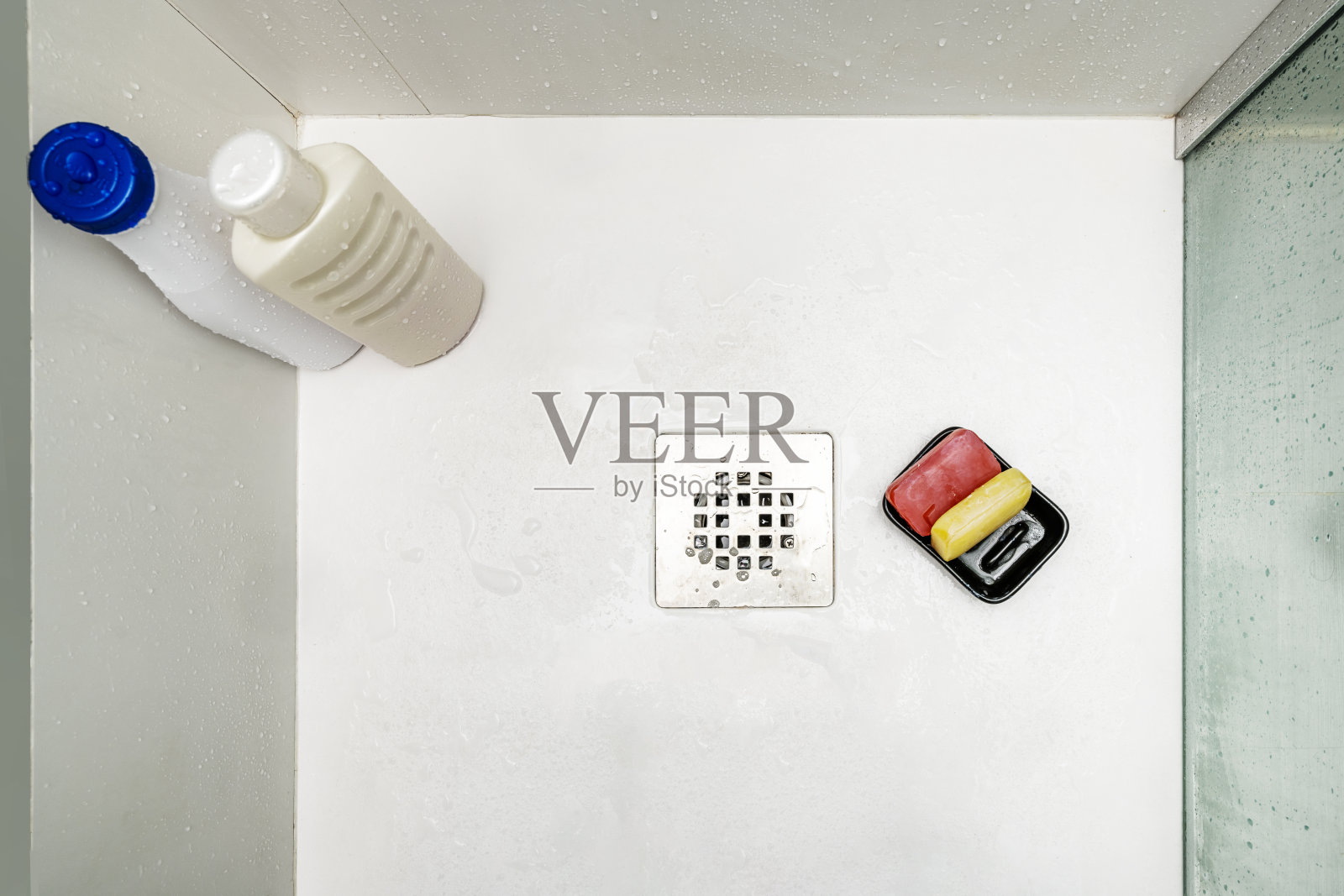 一些红色和黄色的甘油皂块湿漉漉地放在不锈钢水槽上照片摄影图片