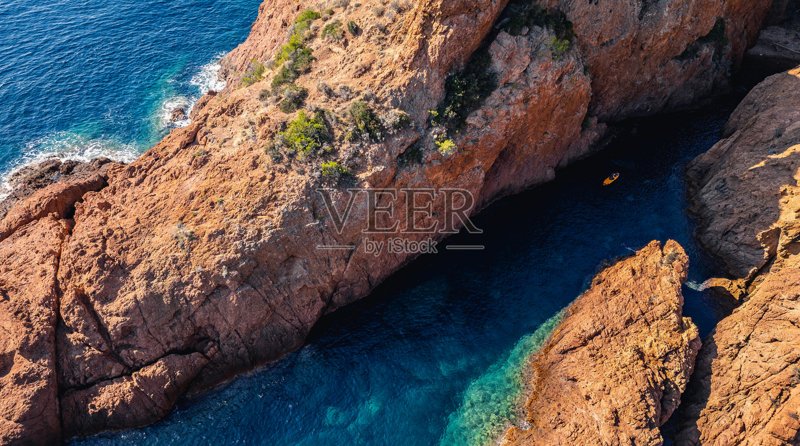 法国里维埃拉南部法国埃斯特雷勒山脉红色悬崖之间的海湾的全景航拍图，水上有冲浪板，地中海，风景如画的海岸线，绿松石般的海水照片摄影图片