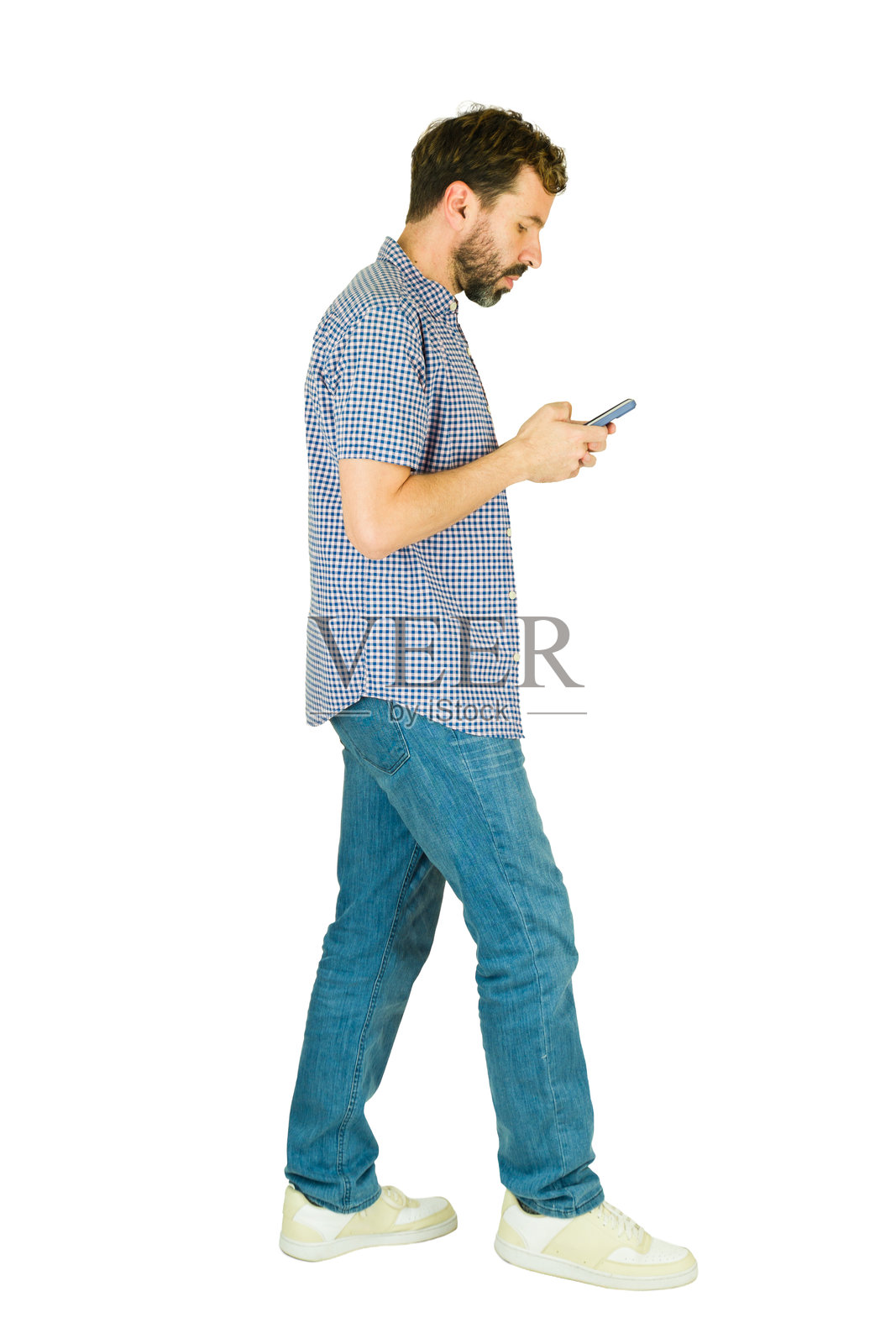 男人边走边用手机发信息的侧面照照片摄影图片