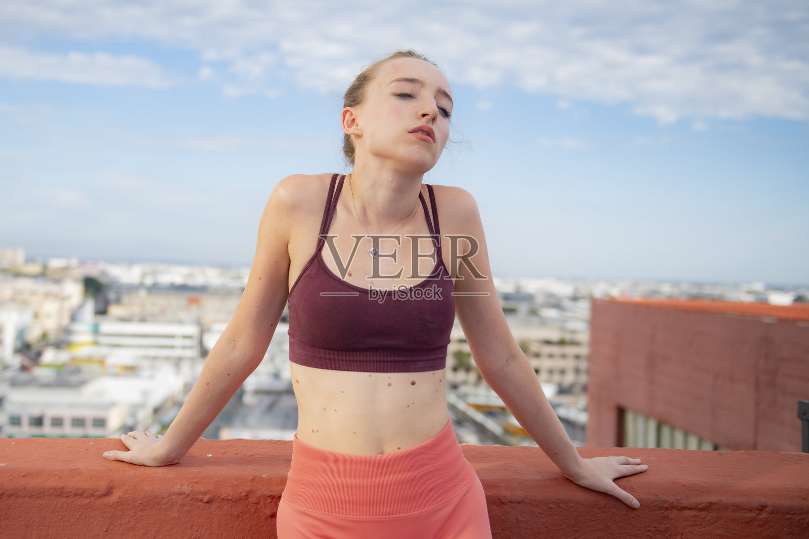 年轻女子表情内省，享受着屋顶的景色和都市的氛围照片摄影图片