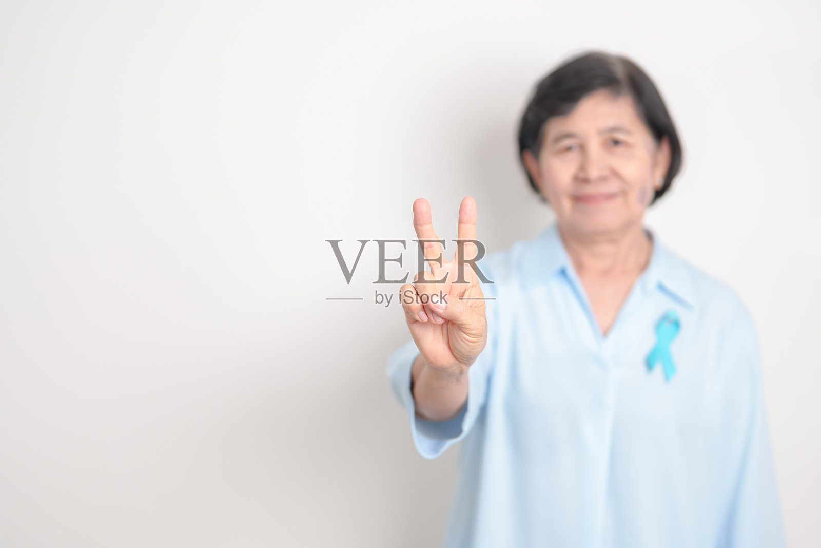 老年人佩戴蓝色丝带，象征蓝月（十一月前列腺癌宣传月）、世界糖尿病日、男性健康月、国际男性日、父亲节、医疗保健和世界癌症日。照片摄影图片