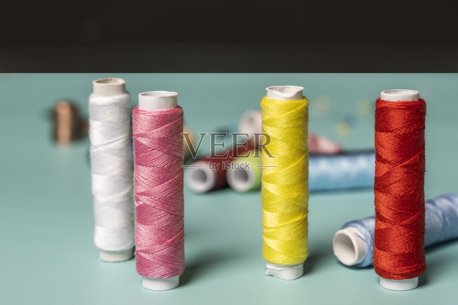 全新彩色线轴放在光滑的蓝色表面上照片摄影图片