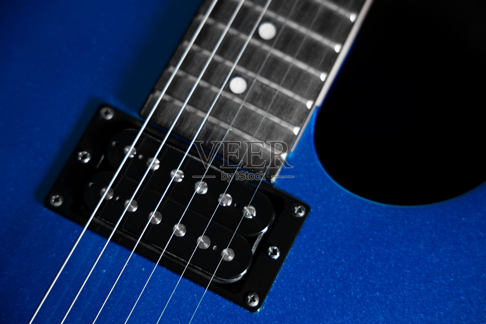 黑色背景下的蓝色电吉他，特写琴弦、拾音器和琴桥，用于摇滚和录音室设计的乐器概念。照片摄影图片